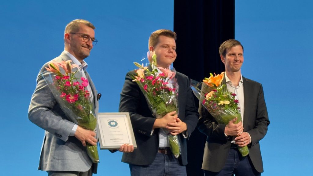 Innovaatiopalkinto 2025. Kuvassa Entteri Professional Software Oy:n edustajat vastaanottamassa palkintoa, kukkakimput käsissä.