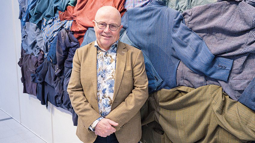 Niek Opdam Apollonia Symposiumissa 2026. Kuvassa Opdam paidoista tehdyn taideteoksen edessä