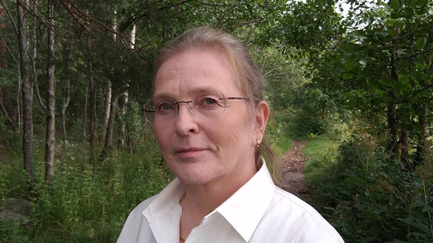 Anna Haukka väittelee 11.9.2026. Kuvassa väittelijä valkoisessa kauluspaidassa ja metsäpolku takana.