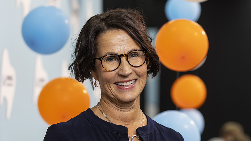 Annamari Nihtilä: Hyvä potilashoito vaatii monenlaista osaamista. Taustalla ilmapalloja Hammaslääkäripäivien väreissä.